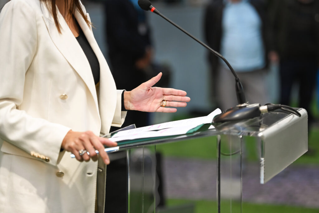 Person speaking at a podium with microphone.