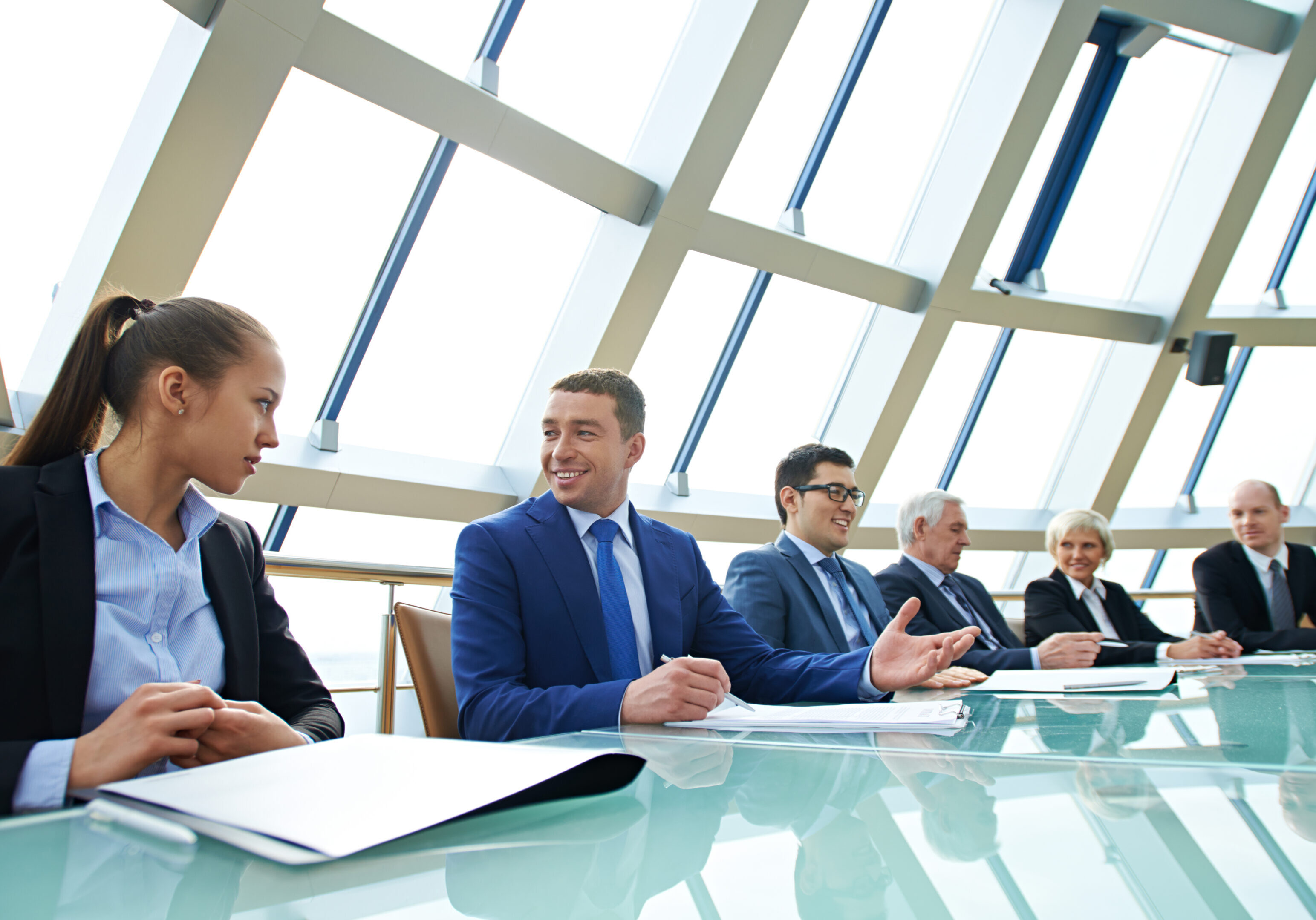 Business meeting with six professionals at table.